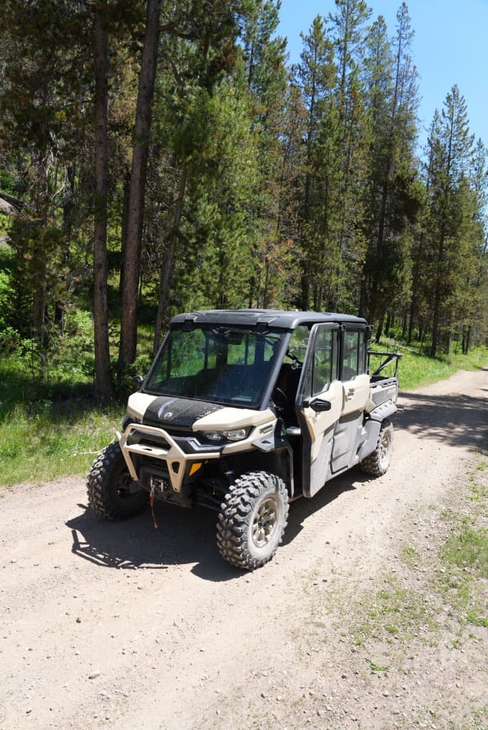 Rugged Can-Am Commander Max XT showcasing 14-inch suspension travel over backcountry rocks entirely separated from the pavement in Island Park.